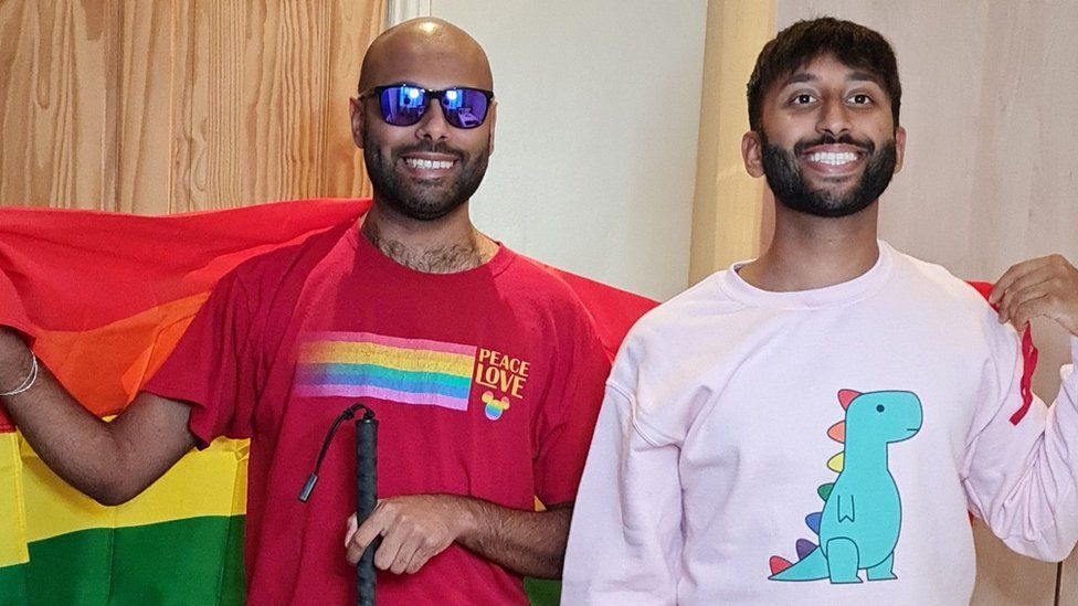 Yahya and his brother. Yahya is holding a rainbow flag