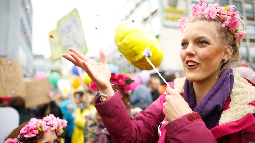 Woman wearing flowers on head with balloon in hand
