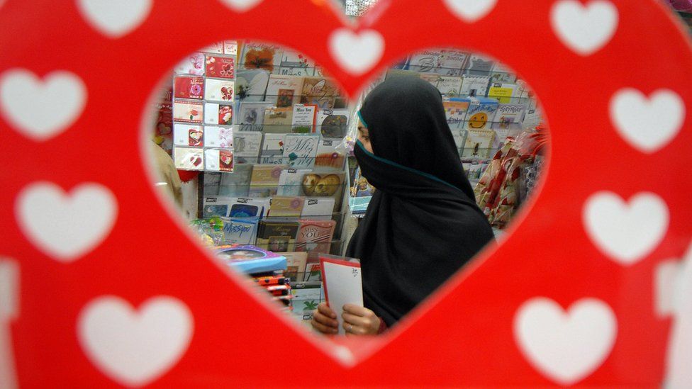 A young Pakistani woman browses through Valentine's Day cards at a shop in Peshawar, 13 February 2008 in advance of the 14 February celebration of love
