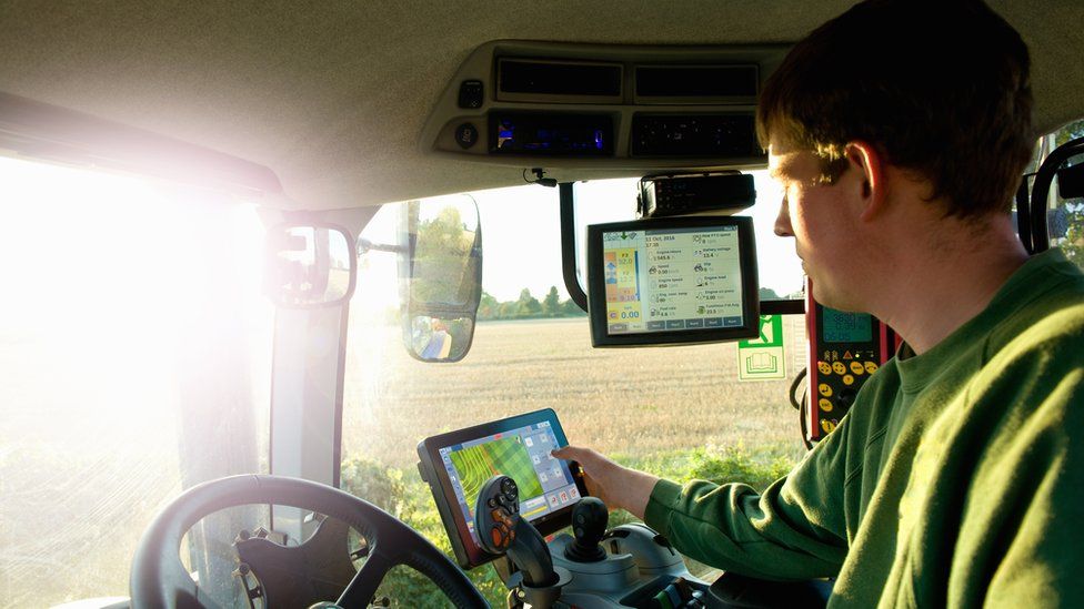Farmer uses GPS in tractor