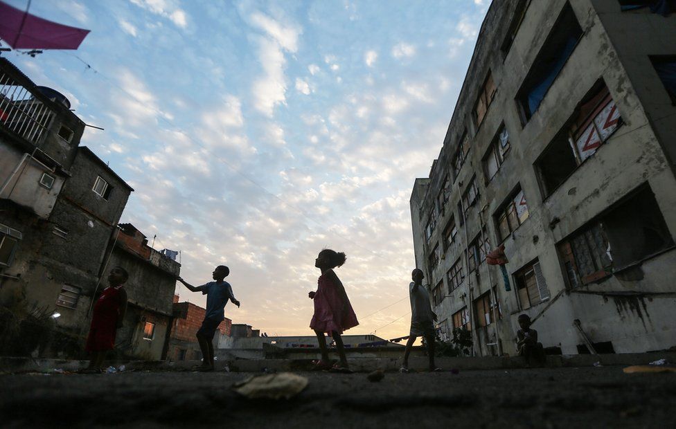 Youngsters fly kids outside an occupied building in the Mangueira 'favela' community on 9 August, 2016