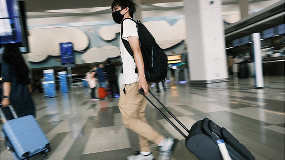 A airport traveller wearing a mask