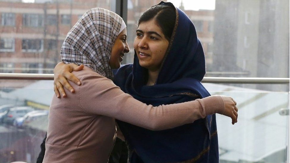 Malala Yousafzai (right) greets 17- year-old Syrian refugee Muzoon Almellehan at the City Library in Newcastle Upon Tyne (22 December 2015)