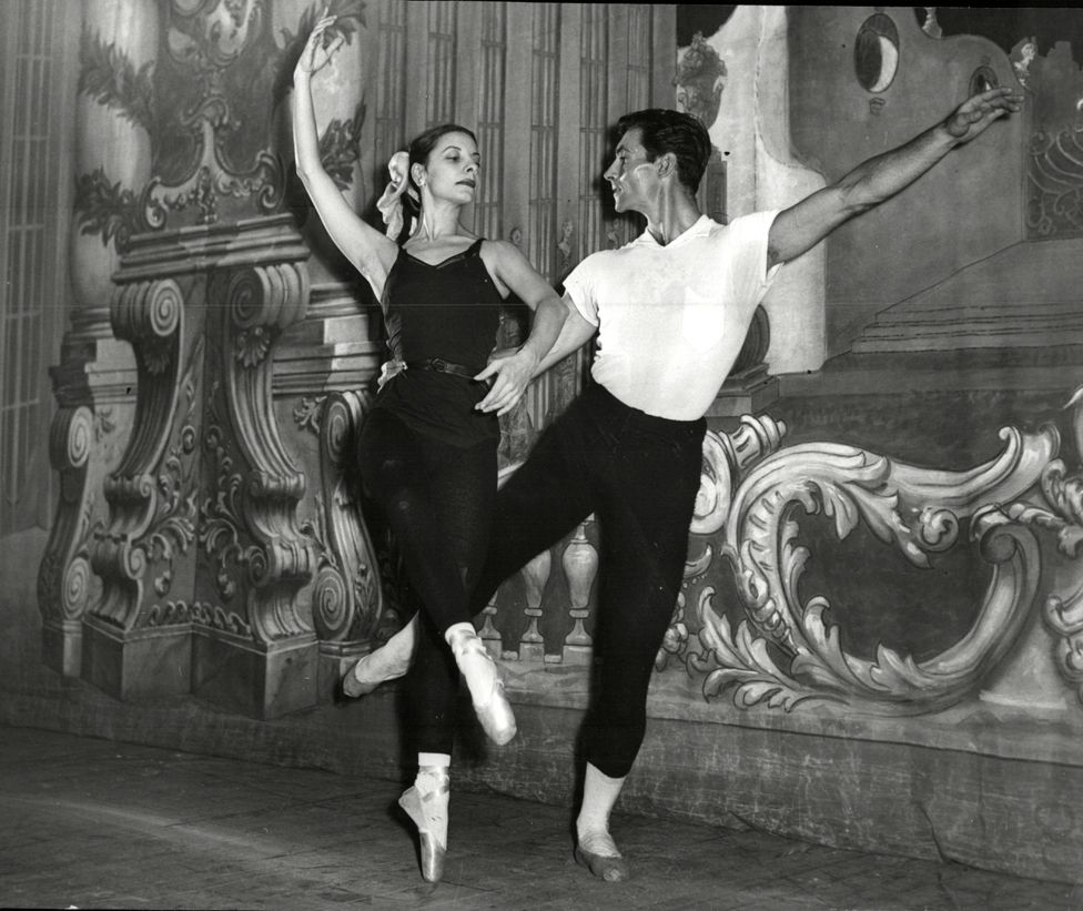 Alicia Alonso and Igor Youskevitch dance before a gilded backdrop