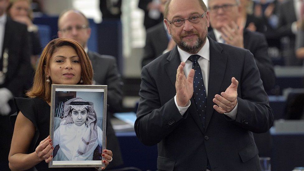 Энсаф Хайдер держит фотографию Раифа Баддави, получающего премию Сахарова за свободу мысли от президента Европейского парламента Мартина Шульца в Страсбурге, 16 декабря 2015 г.