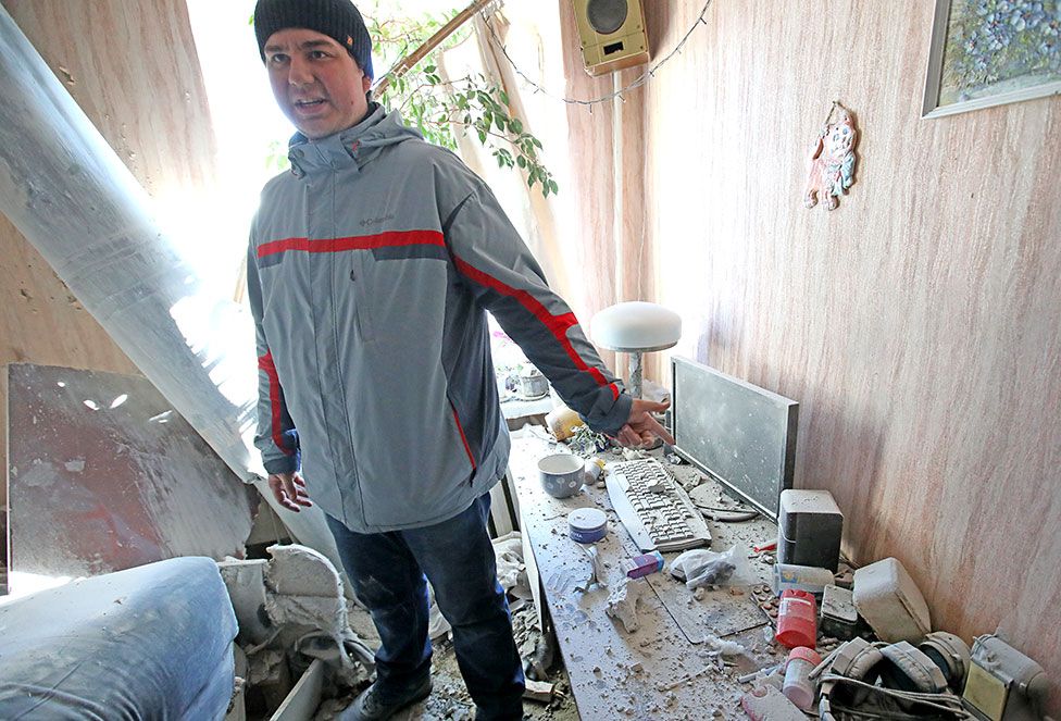 A man shows a bomb-damaged room from shelling by Russian troops in a residential area in Piatykhatky, Kharkiv, north-eastern Ukraine