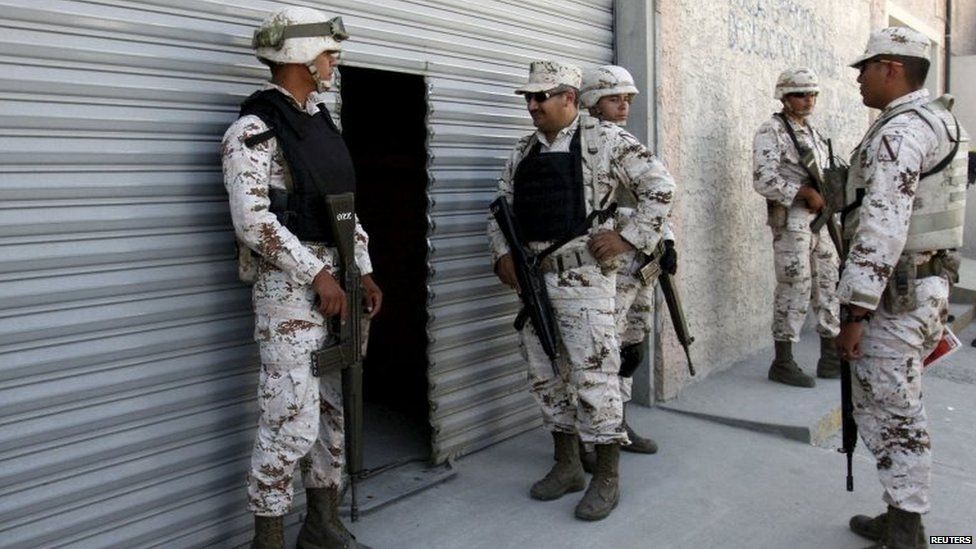 Mexican soldiers stand guard outside a warehouse containing a tunnel discovered in Tijuana on 2 August, 2015