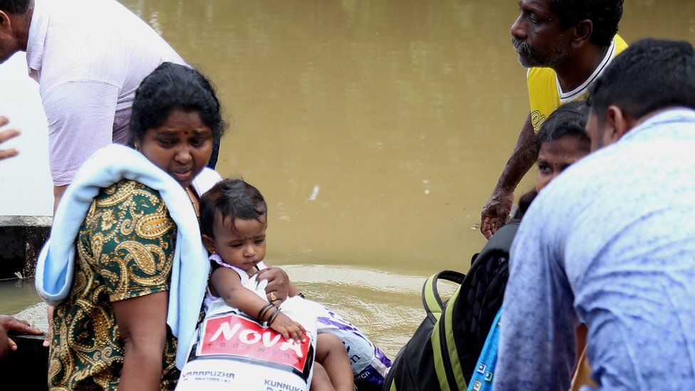 People take a boat to safety in Kochi