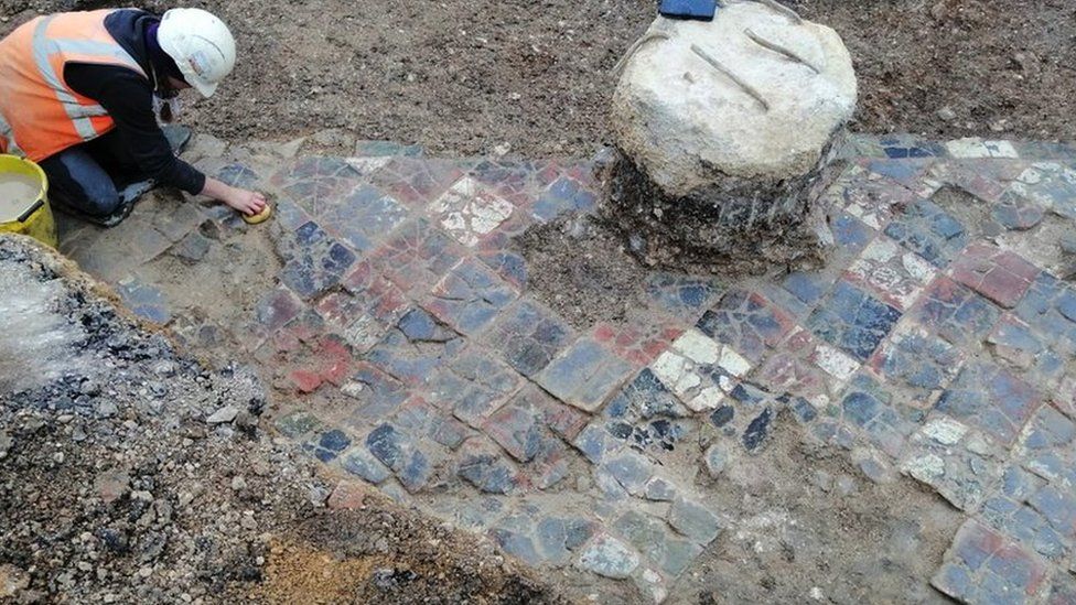 An archaeologist cleaning the tiles