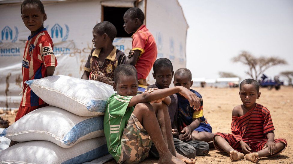 Children seat by their shelter in Goudebou, a camp that welcomes more than 11,000 Malian refugees in northern Burkina Faso, on International Refugee Day on June 20, 2021.