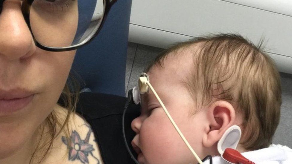 Mother and nine-month old baby with hearing aids