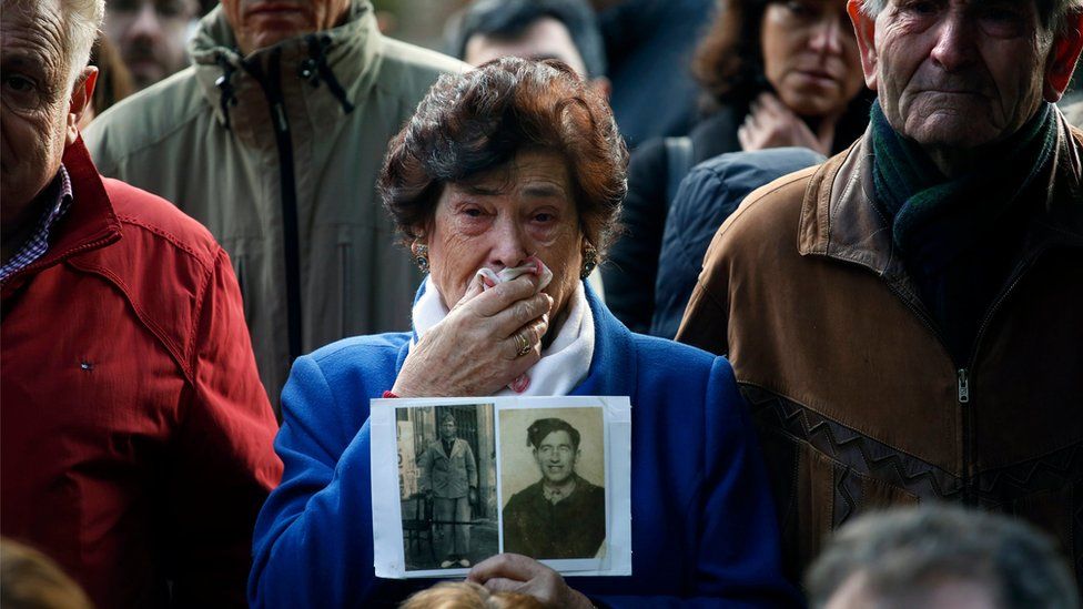Carmen Benito Alcantarilla holds a picture of her uncle Valentin Alcantarilla Mercado during the exhumation of graves in Guadalajara's cemetery, Spain, 30 January 2016