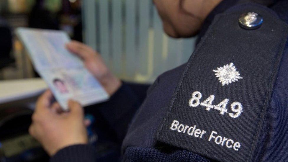 Border Force official checking passport