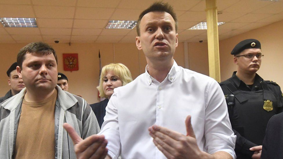 Russian opposition leader Alexei Navalny, right, and his former colleague Pyotr Ofitserov, left, speak to journalists in the court in Kirov, Russia, Wednesday, Feb. 8, 2017