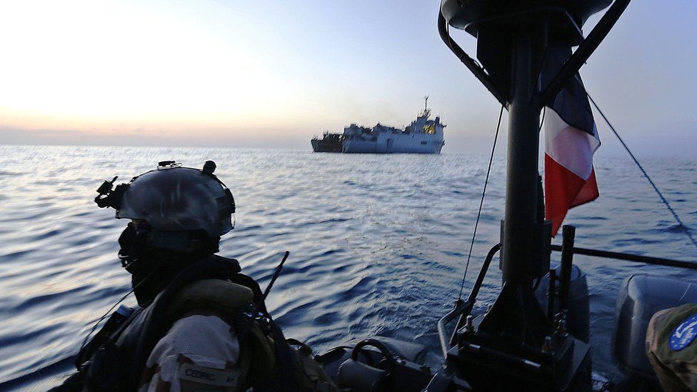 French marine commandos operate on a speed boat just off the French frigate Sirocco as part of the EU naval force combating piracy off the coast of Puntland on 26 March 2014.