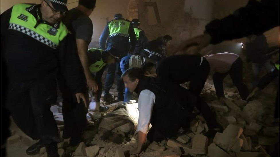 Police and passers-by look for victims in the rubble, minutes after the collapse of the old Parravicini movie theatre building, in Tucuman, Argentina on May 23, 2018.