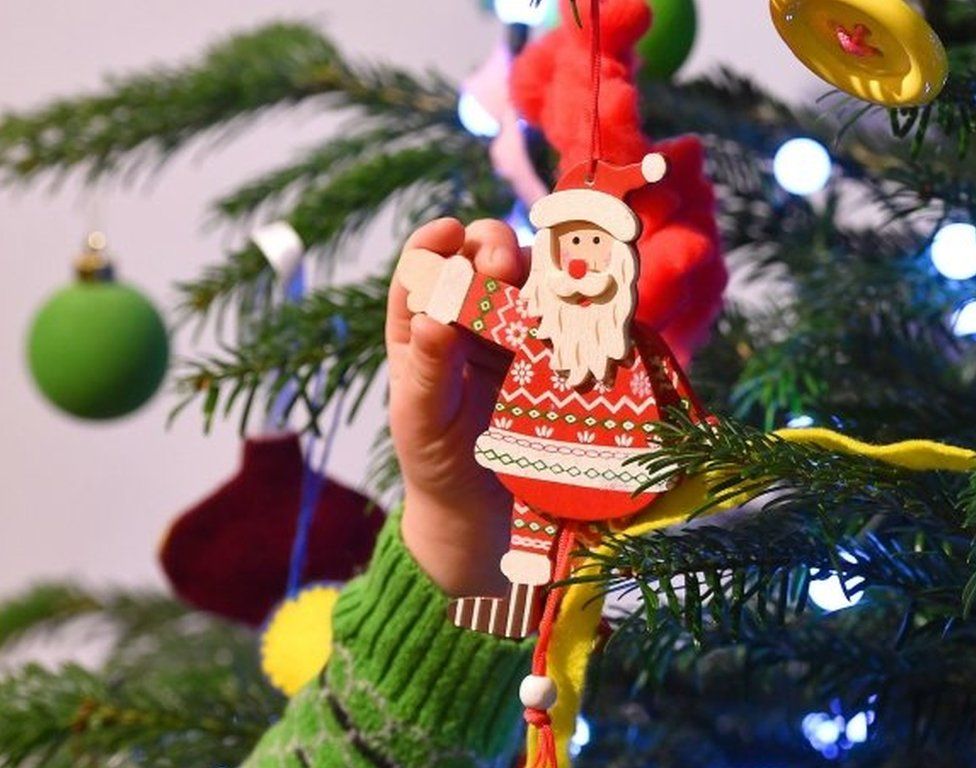 Child decorates a Christmas tree