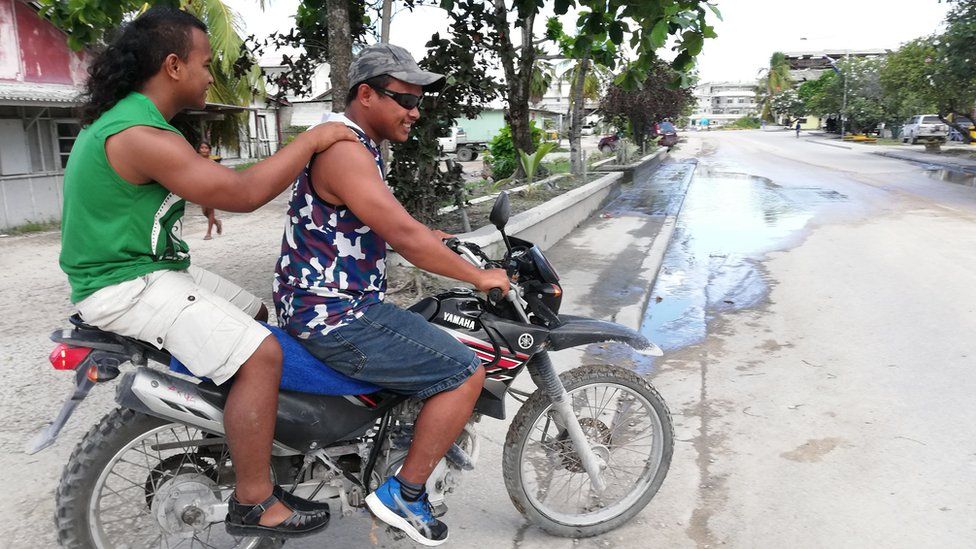 Two men riding their motorbike on the quiet streets of Aiwo on the Pacific island of Nauru on 1 September 2018