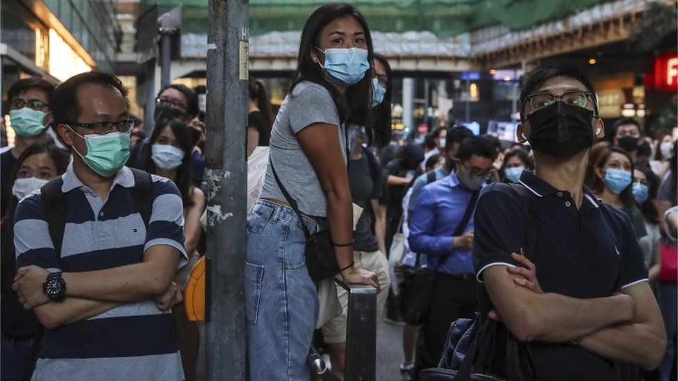 Demonstrators defiantly wear face masks after the legislature passed emergency measures banning them