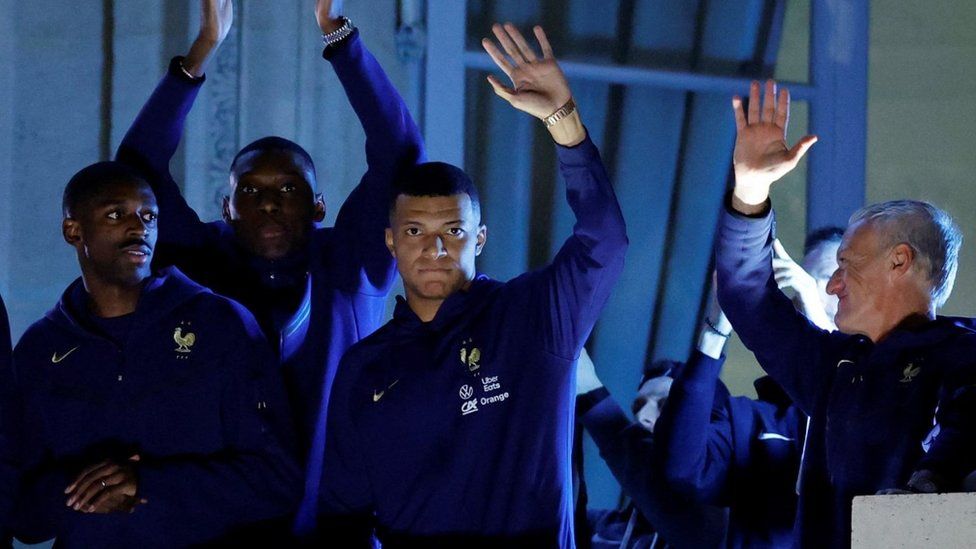 France's Kylian Mbappe and teammates greet the fans from a balcony