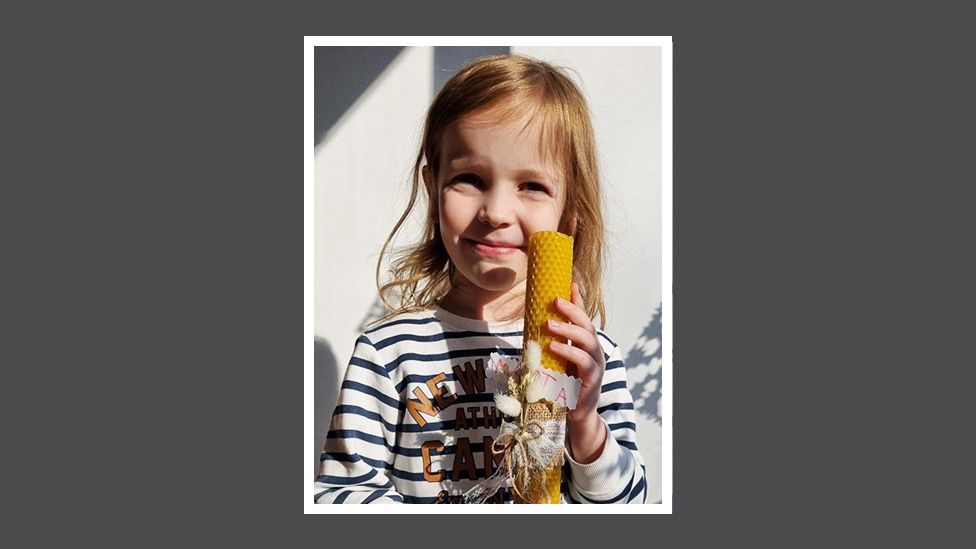 Ihor's daughter Marta holds a candle she made