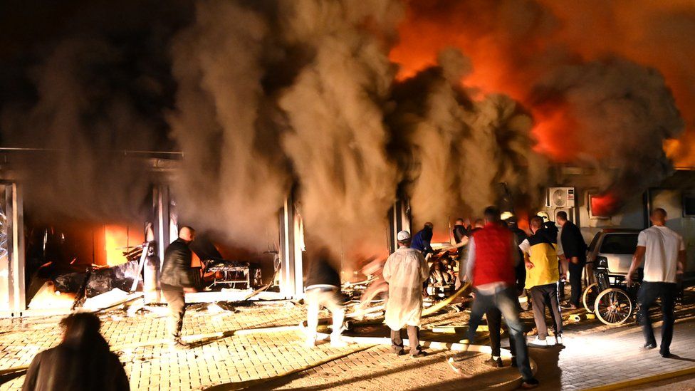 Smoke rises as firefighters and civilians try to extinguish a blaze that broke out at a hospital for Covid-19 patients in Tetovo, Republic of North Macedonia, 8 September 2021