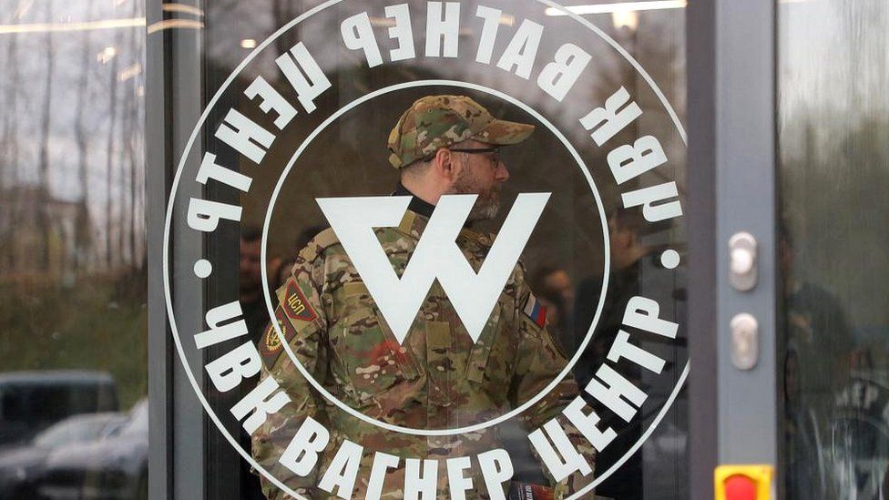 A man wearing a camouflage uniform walks out of PMC Wagner Centre, which is a project implemented by the businessman and founder of the Wagner private military group Yevgeny Prigozhin, during the official opening of the office block in Saint Petersburg, Russia, on 4 November 2022