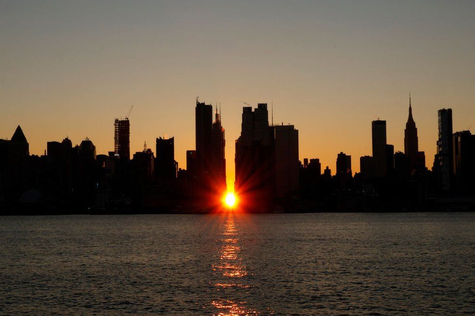 The sun rises over 42nd street during a sunrise Manhattanhenge in New York City on November 29, 2023, as seen from Weehawken, New Jersey.