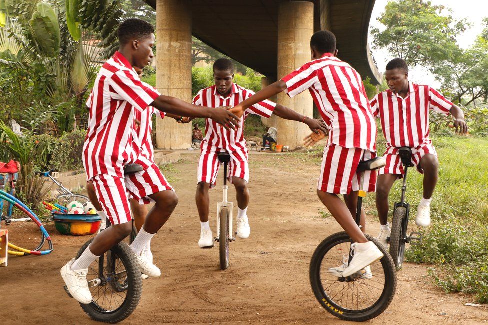 Street children practise acrobatics on unicycles in Lagos, Nigeria - Monday 14 August 2023