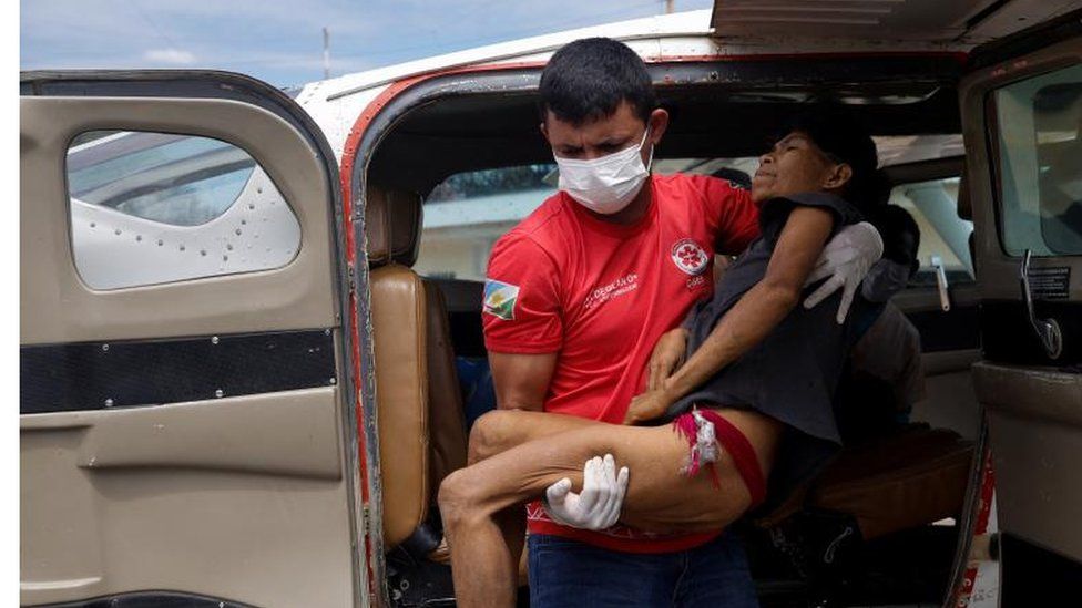 A health worker carries a Yanomami woman suffering from malaria, who was removed from indigenous land, as she leaves the airplane to be treated in Boa Vista, Roraima state, Brazil, January 29, 2023