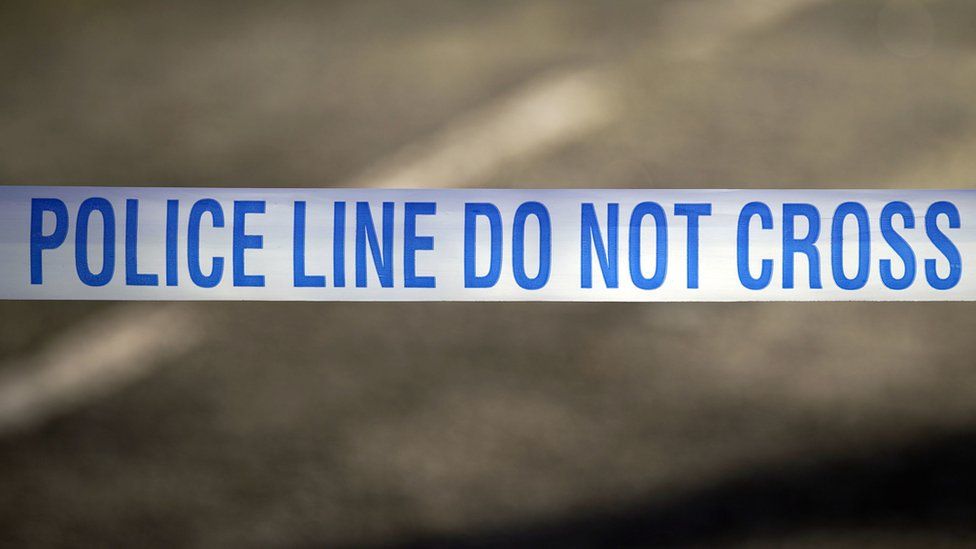 Police tape near a scene of a suspected crime