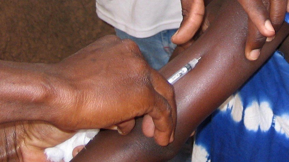 A health worker vaccinates a girl against meningitis