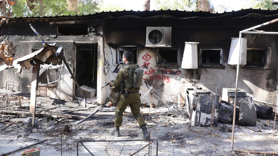 Soldier walks through Kibbutz Nir Oz