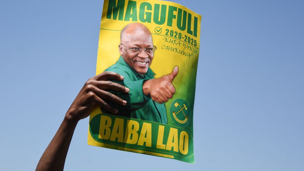 A supporter of President John Magufuli holds a sign during the official launch of the party's campaign for the October general election