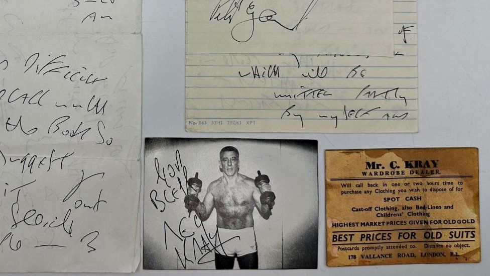 A signed black and white photo of Kray boxing and a brown business card from his father