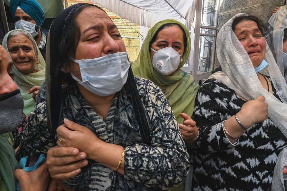 Родственники убитого директора государственной школы Супиндера Кур скорбят во время похоронной процессии в Шринагаре 8 октября 2021 года, на следующий день после того, как подозреваемые антииндийские боевики застрелили двух школьных учителей в управляемом Индией Кашмире.