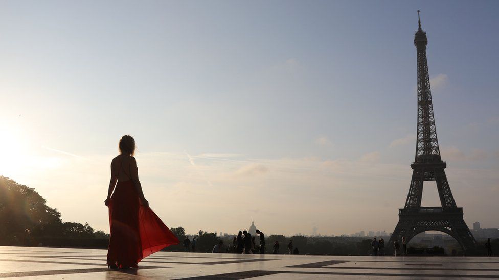 Woman in red dress looking at Eiffel Tower