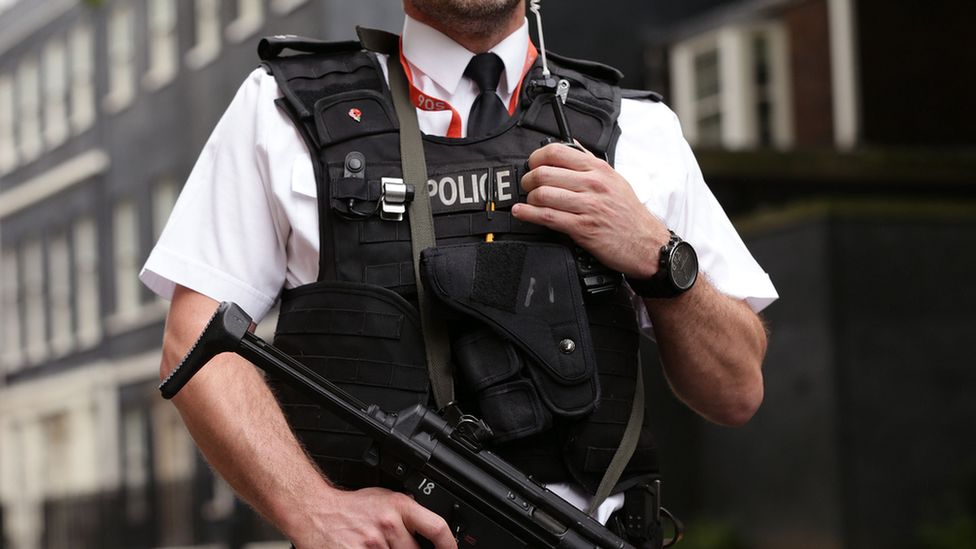 Armed anonymous Metropolitan Police AFO officer with machine gun (automatic rifle) on duty in Downing Street, central London September 1st 2014.