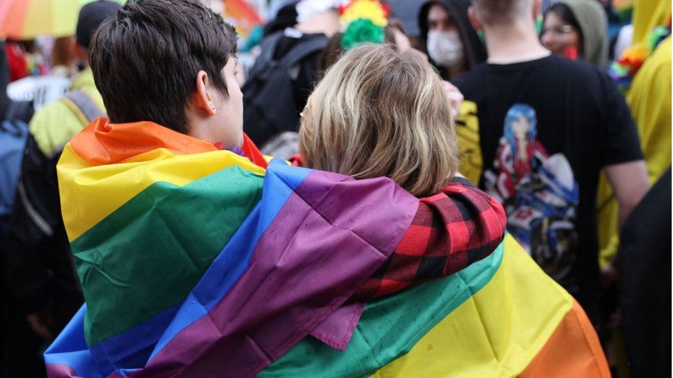 Two people with a pride flag