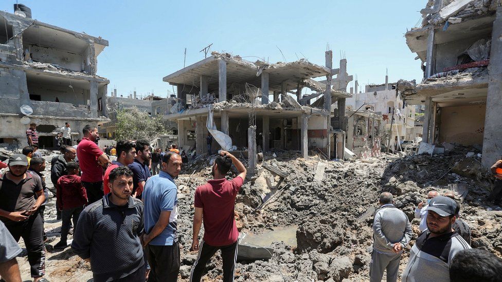 A group of men standing by bombed out buildings in Gaza