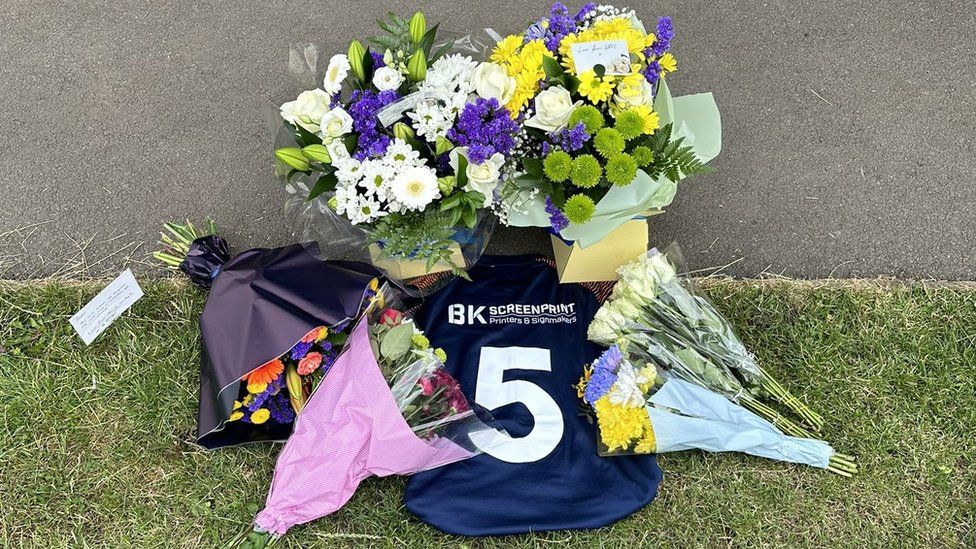 Flowers and a Number 5 football shirt at the club