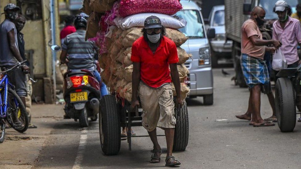 A labourer pulls a cart loaded with vegetables at the main market in Colombo on August 31, 2021 following Sri Lanka's declaration of state of emergency over food shortages as private banks ran out of foreign exchange to finance imports.