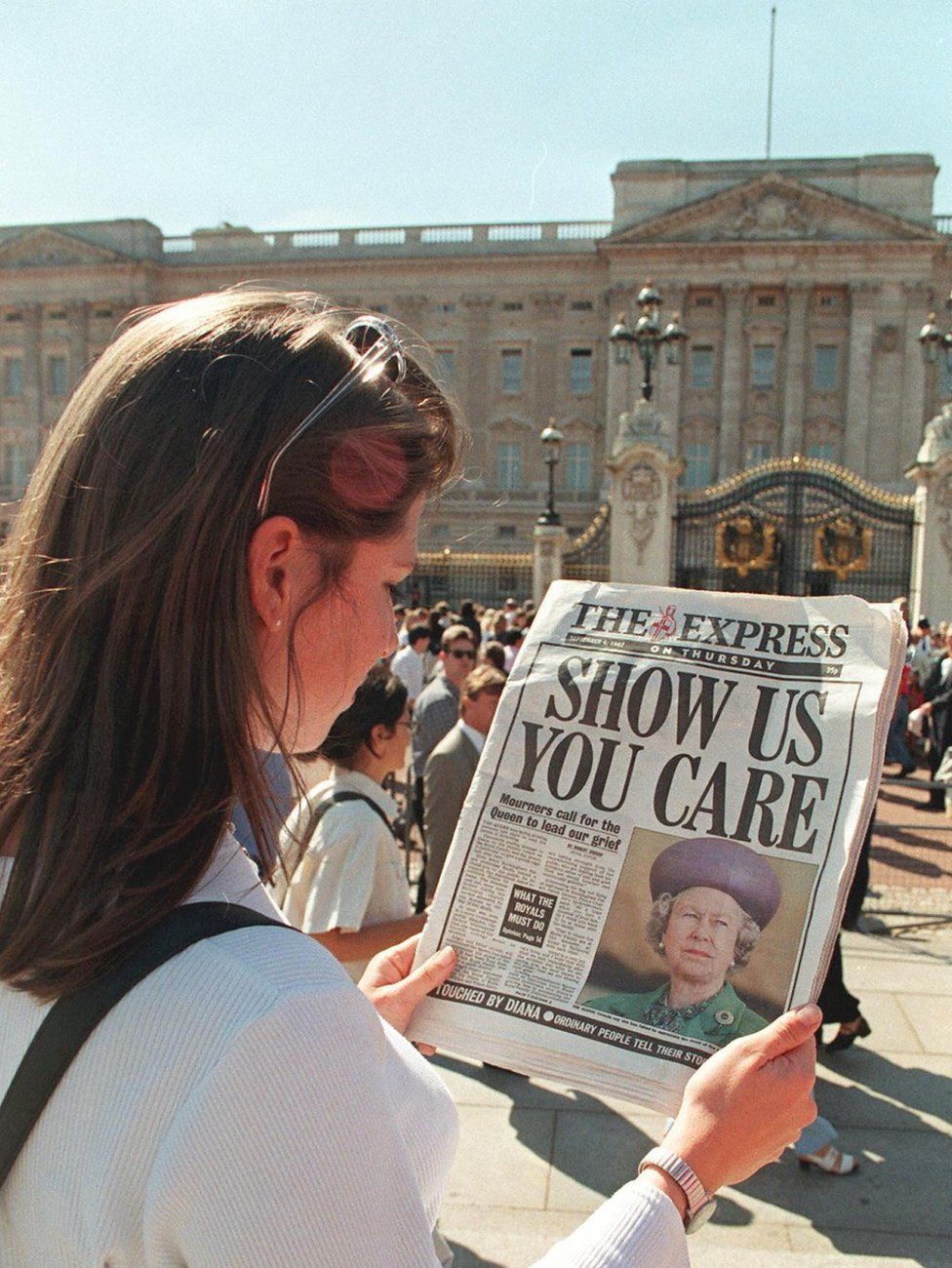 A woman reads a newspaper headline from 4 September 1997, criticising the Queen's silence since the death of Diana, Princess of Wales, the previous weekend