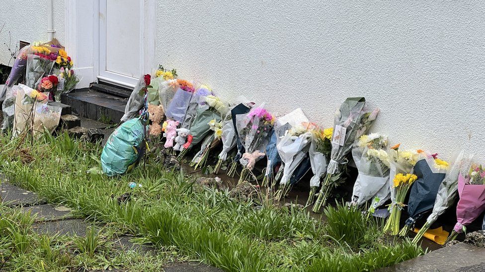Flowers left by the house in tribute of the children