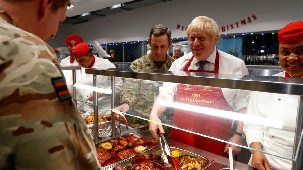 British Prime Minister Boris Johnson serves soldiers in the canteen during his visit to British troops of the NATO enhanced Forward Presence battle group in Tapa, Estonia December 21