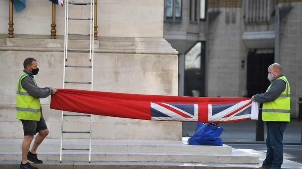 Contractors prepare to hoist a fresh flag of the Merchant Navy on the Cenotaph war memorial on Whitehall in central London