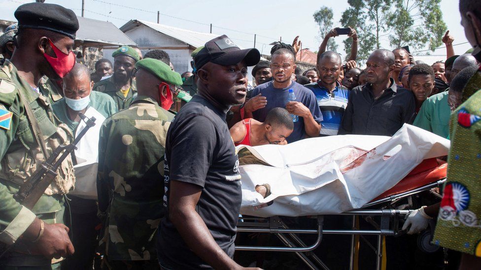Congolese soldiers and civilians receive the body of a Congolese soldier shot dead in Rwanda