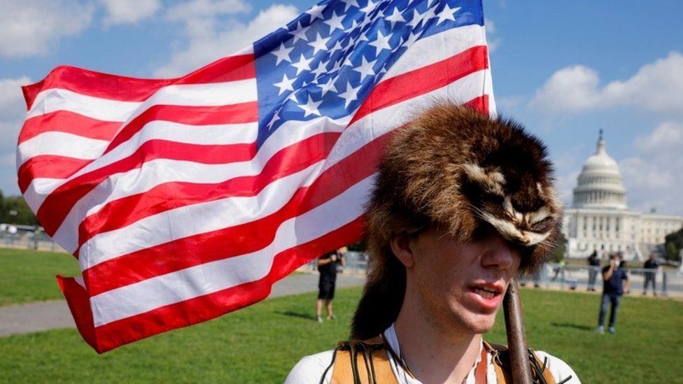 A man wearing a raccoon hat talks about his belief that Donald Trump won the election