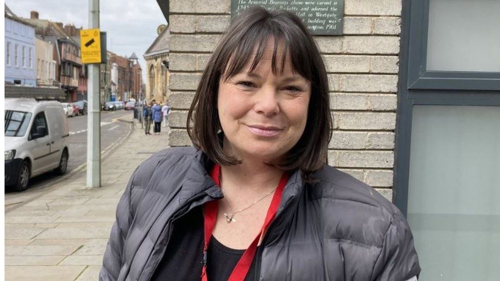 Sarah Fairbairn, the charity's outreach lead, standing outside a house in Gloucester