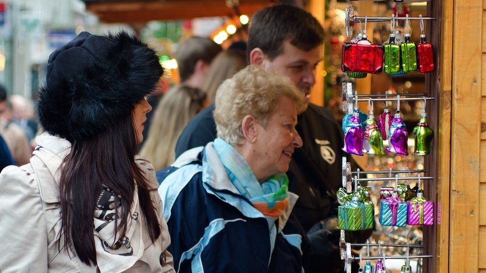 Customers browse a stall at the German market